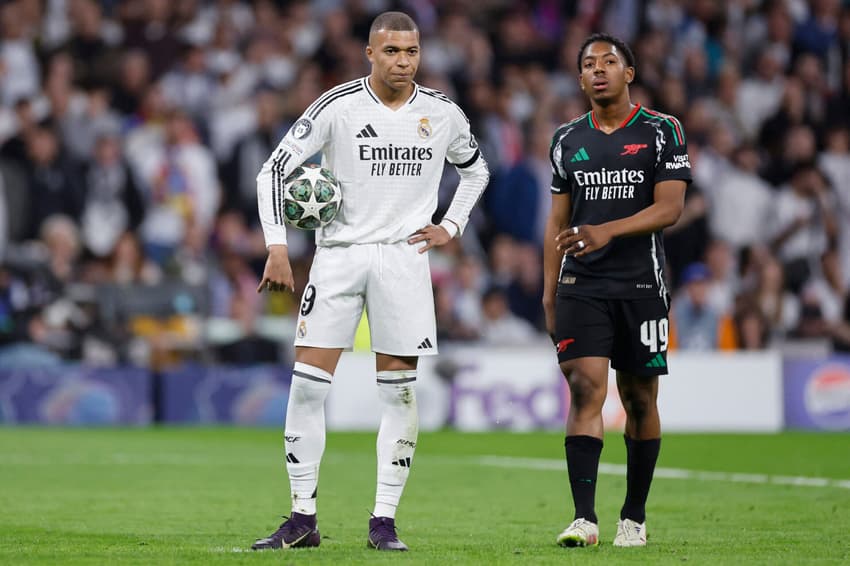 Mbappé segura a bola na mão no jogo entre Real Madrid e Arsenal, pela Champions League