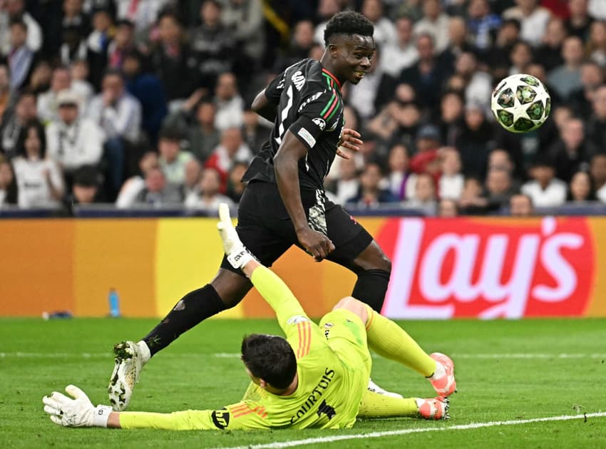 Saka toca por cima de Courtois para abrir o placar para o Arsenal contra o Real Madrid, na Champions League