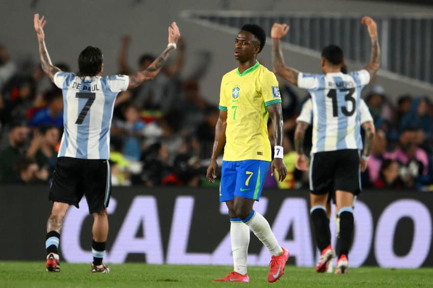 Vini Jr lamenta, enquanto jogadores da Argentina comemoram gol sobre o Brasil